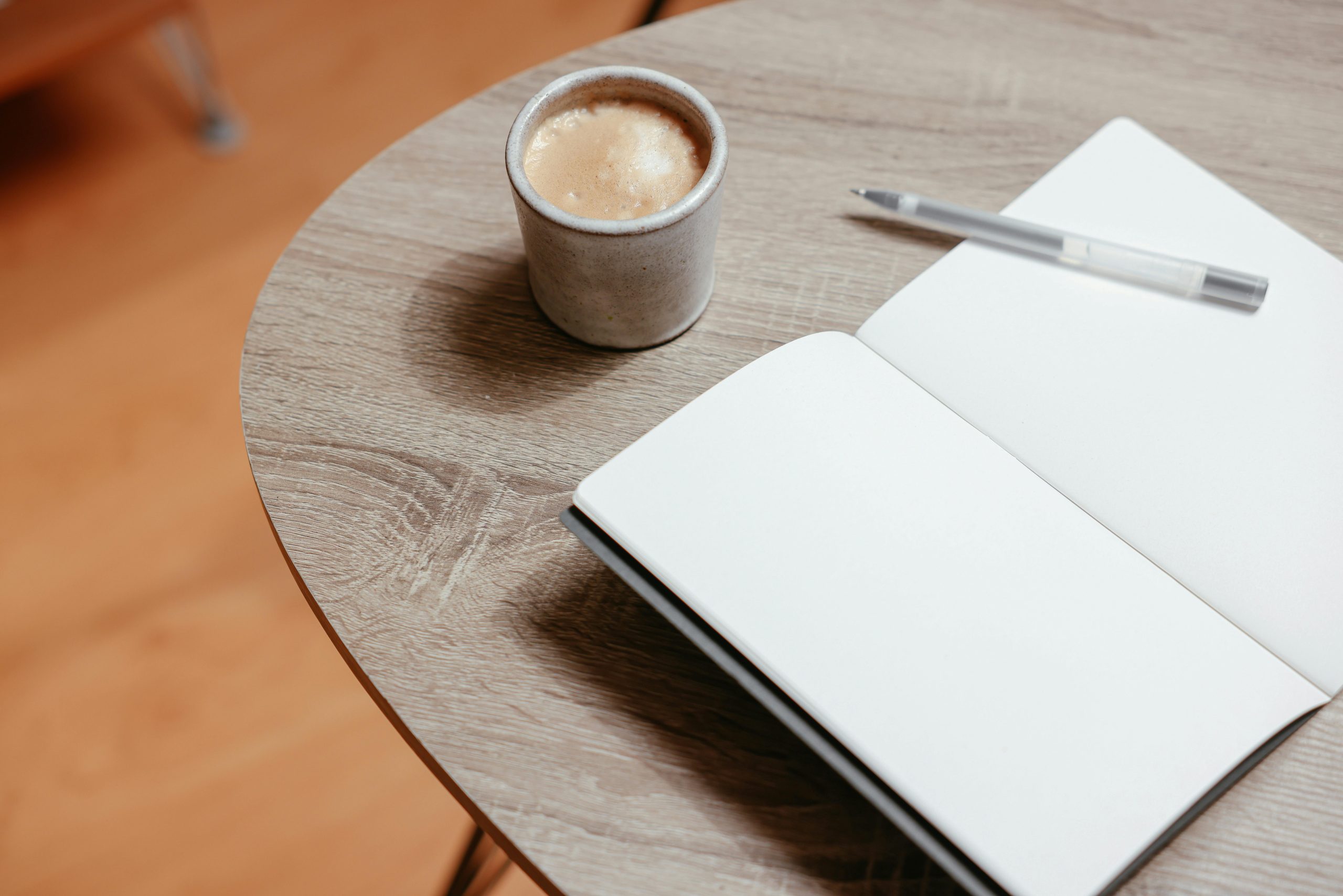Notebook and coffee on a table representing a simple weekly money routine in Australia