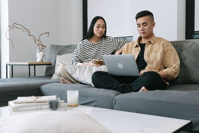 Immigrant couple sitting together looking at their finances in Australia