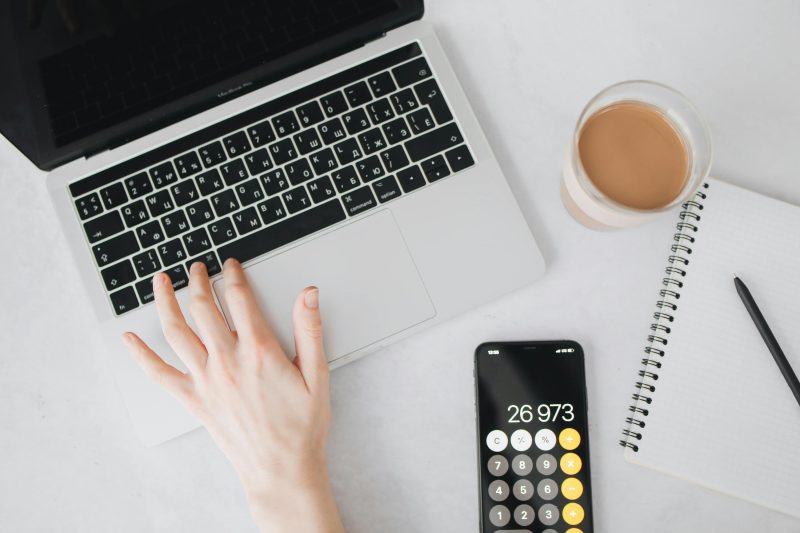 Calculator, coffee, and notebook symbolising budgeting after receiving a first payslip in Australia