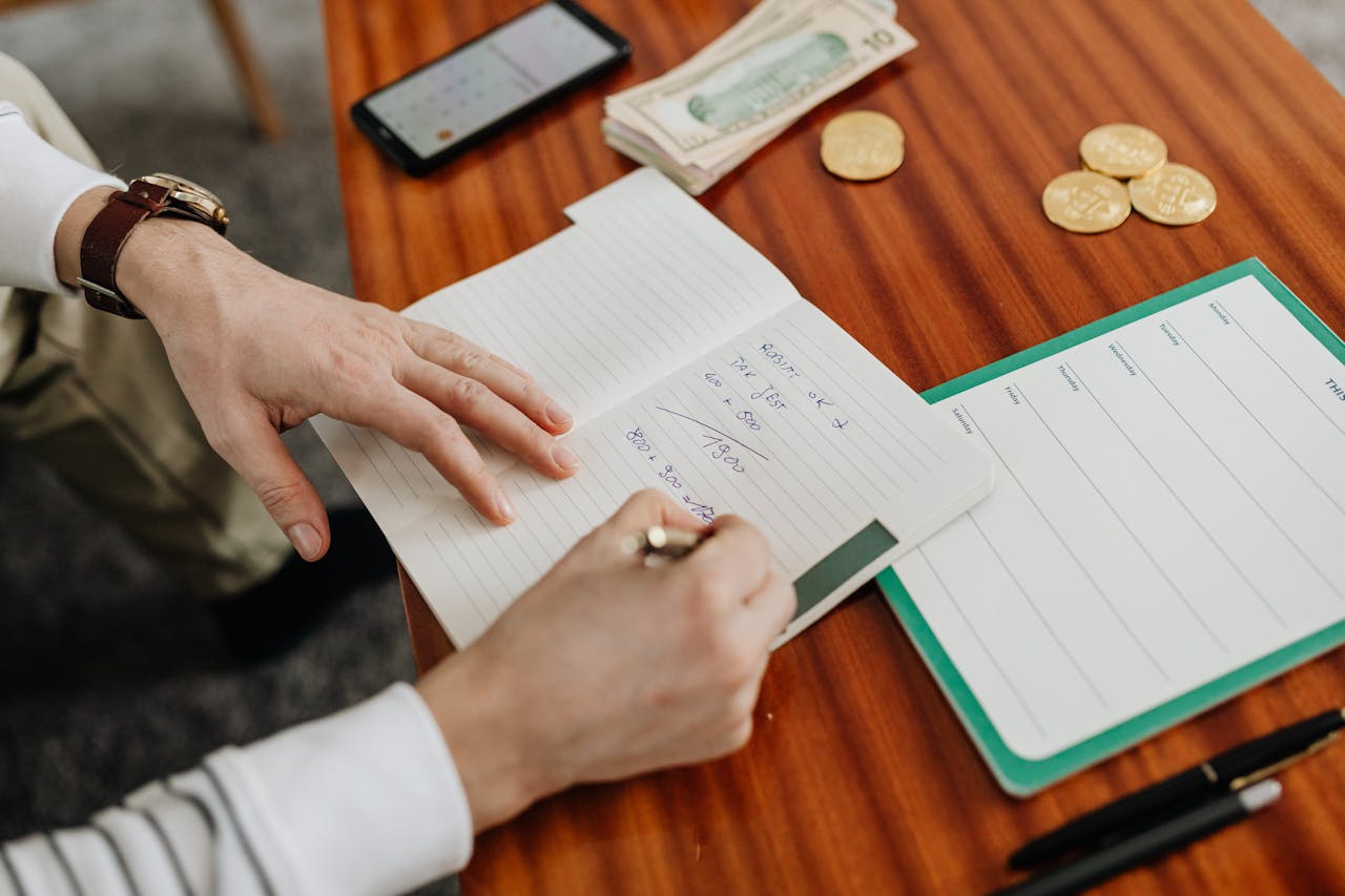 Person writing a budget to build credit score in Australia without a credit card