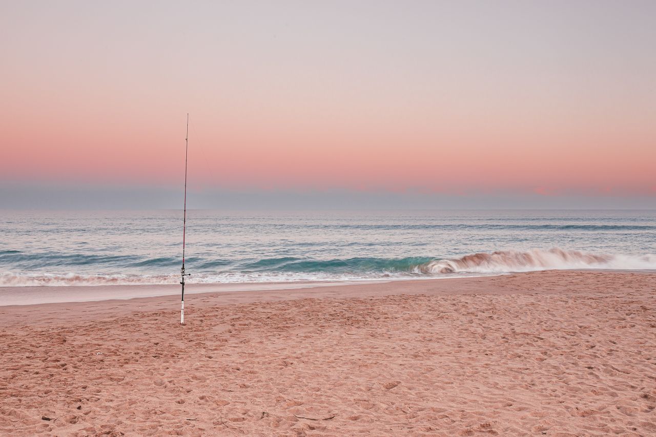 Empty Australian beach at sunset representing free things to do on a tight budget