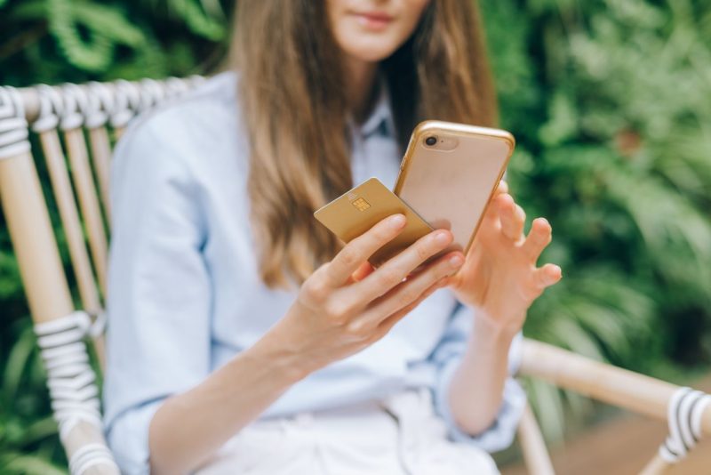 Hand holding a phone showing a banking app