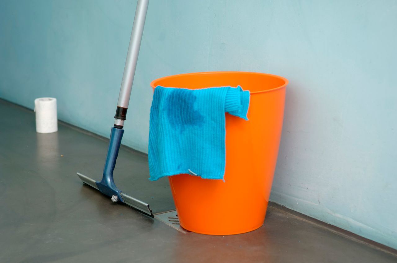 A bucket placed on the floor catching drips from a leaking ceiling