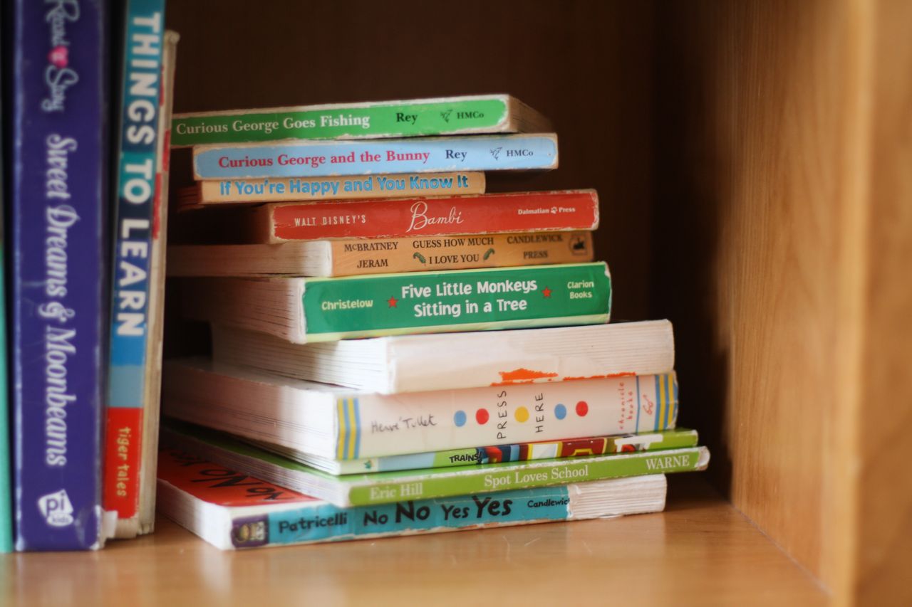 Stack of children's picture books on a library table